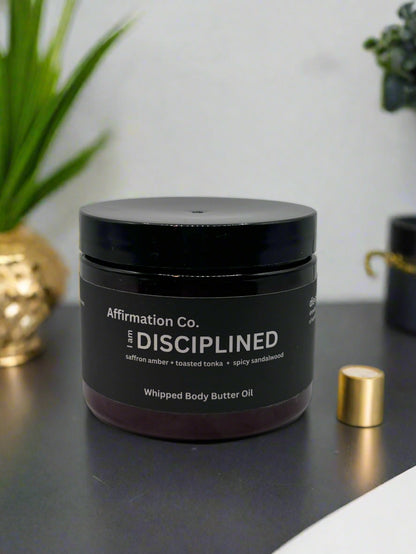 'DISCIPLINED' whipped body butter oil from Affirmation Co. with a modern background
